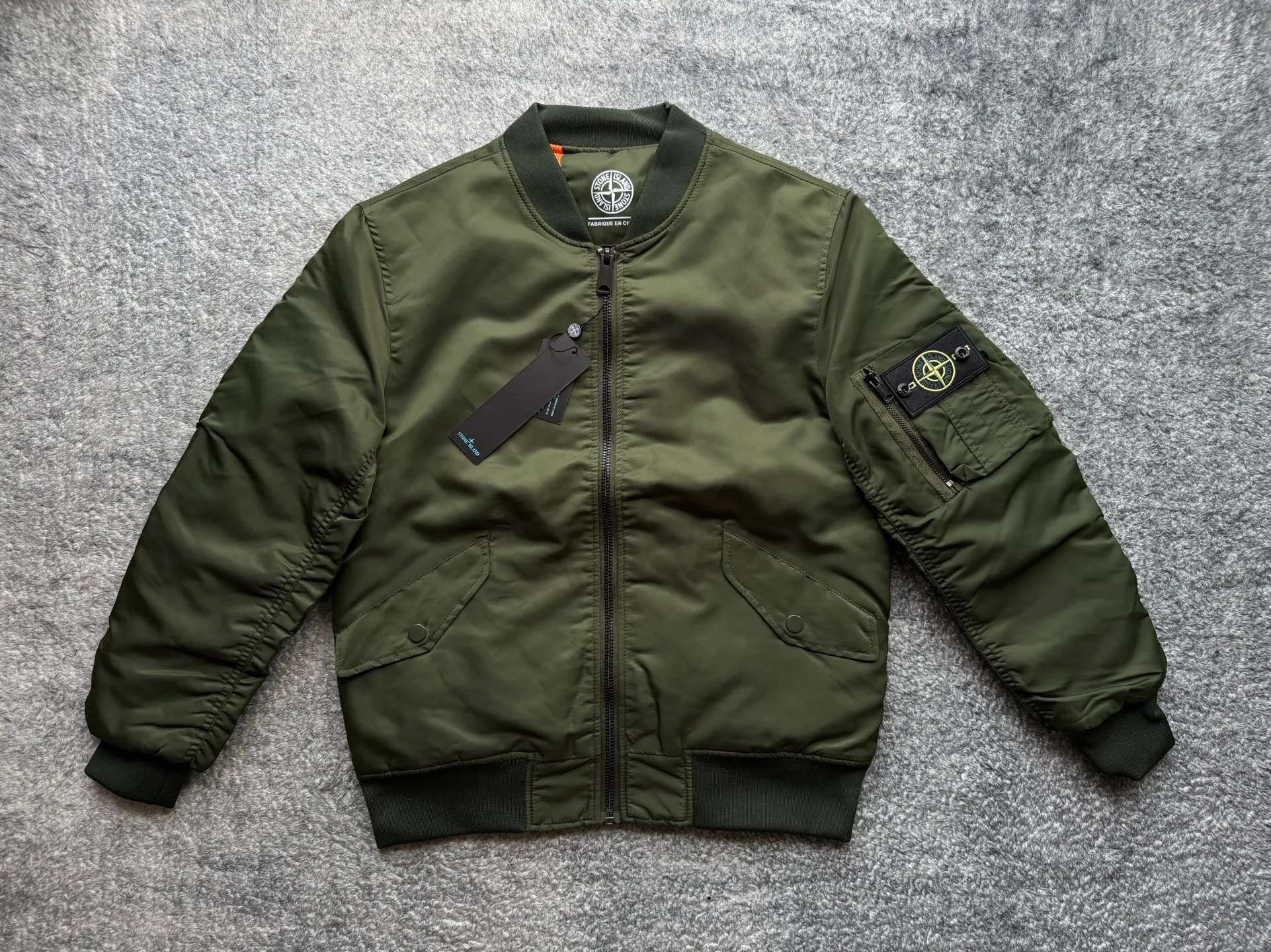 P360 Stone lsland Stone Island Medal Aviator Cotton Jacket The outer fabric is made of MA-1 flight nylon, which is a material specially used in flight and aviation. Flying nylon is a fabric specially used in flight and aviation. It is rarely used in ordinary clothing. The density of flying nylon is very high, so it is windproof and waterproof. When rain falls on the surface of the clothes, it will not penetrate immediately, but will form a small water droplet and slide off. This performance is a requirement for the development of modern jet technology. Because it is assumed that the pilot got caught in the rain before getting on the plane, he entered the cabin covered in rainwater. When flying at high altitude and at high speed, in a cabin without an environmental control system, water droplets will freeze on the pilot's body 2. Knitted baseball collar MA-1 uses a knitted collar. The collar is made of wool and can be snug around the neck and very warm. 3. Metal zippers We have very strict requirements on zippers, including smoothness and size. There was no zipper on the market that met the requirements, so we asked a zipper factory to customize a strong and durable metal zipper.  4. Double-threaded knitted cuffs The cuffs are made of double-threaded knitted fabric, narrow at the front and wide at the back. The narrow part can be tightened around the wrist to prevent wind from entering. The wide part has enough space when wearing multiple pieces under winter Color: Black Dark Army Green Size: M L.